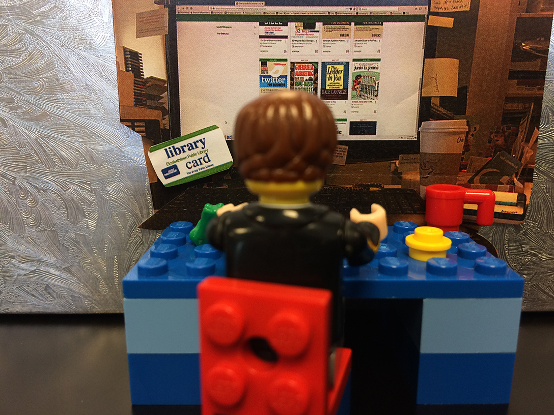 Lego figure sitting at a Lego Library computer