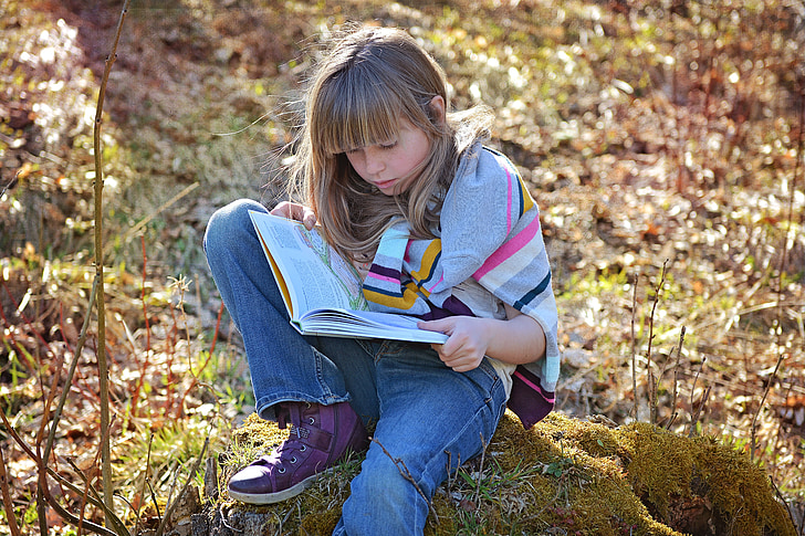 Girl sitting reading outdoors