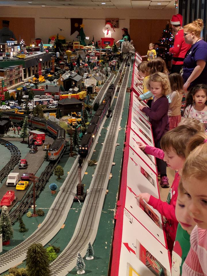 Preschoolers all in a row pushing buttons andenjoying the train display